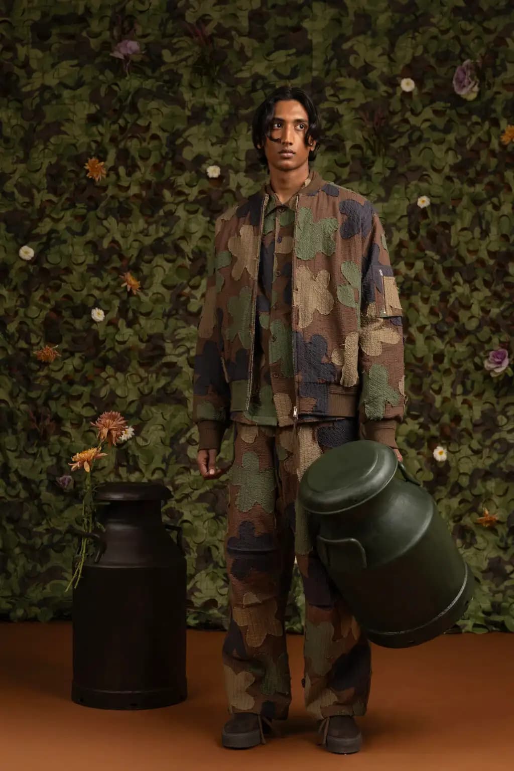 Seated editorial portrait against a dark studio backdrop.