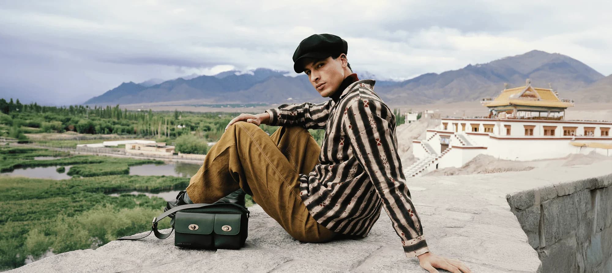 Editorial look in striped outerwear crossing an alpine desert landscape